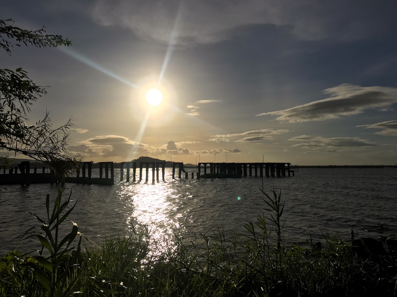 Sunset over a bridge on a lake beach