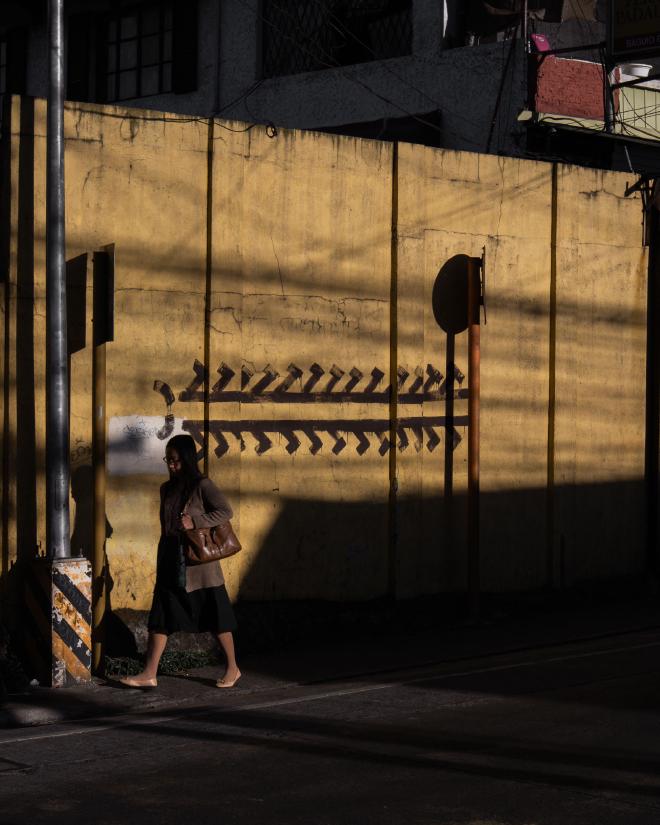 Centipede graffiti behind a woman walking