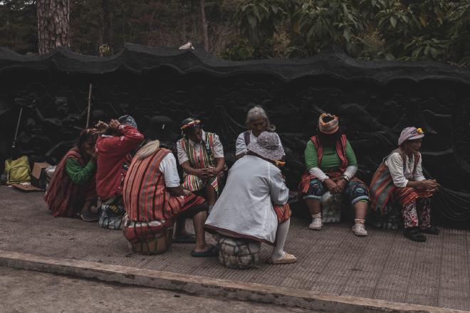 Older women sitting on the sidewalk